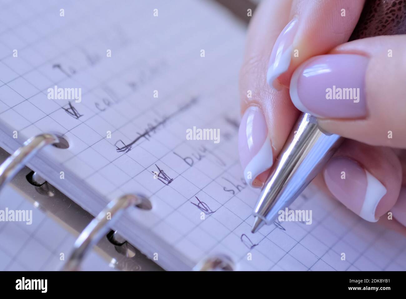 Vista ravvicinata - donna mettendo il riferimento su caselle di controllo della Lista da fare in notebook Foto Stock