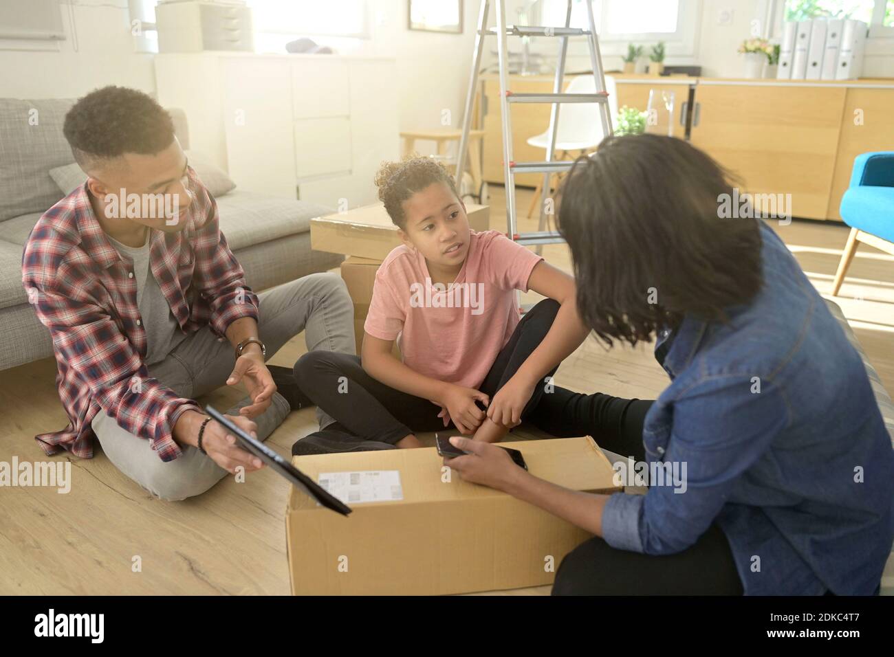 La famiglia recentemente spostata che guarda le cose da comprare in linea per nuova casa Foto Stock