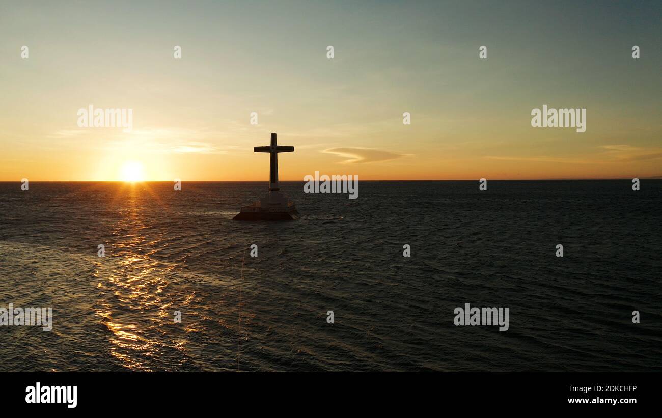 Croce cattolica nel cimitero affondata nel mare al tramonto, antenna fuco. colorato cielo durante il tramonto. Grandi crucafix segnando il sottomarino sunken cimitero, CAMIGUIN ISLAND Filippine. Foto Stock