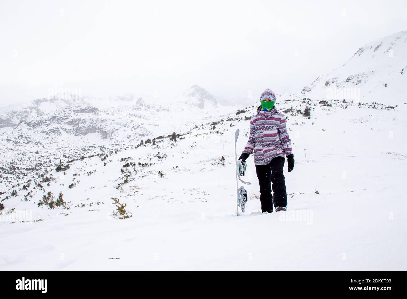 Donna con snowboard in fredda giornata invernale. Maltempo. Tempesta. Foto di alta qualità Foto Stock