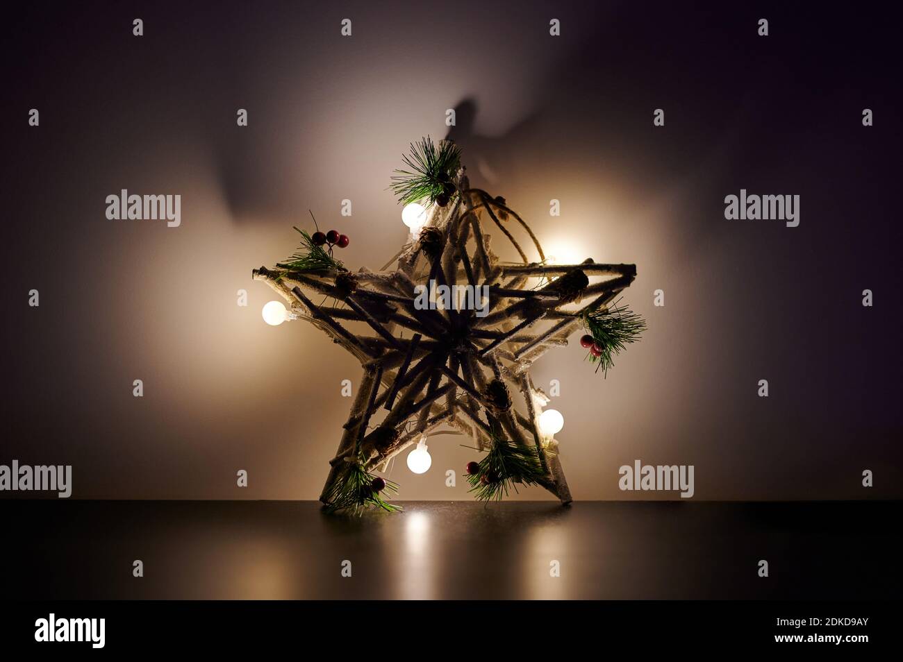 Ornamento a stella con luci sullo sfondo della parete vista ravvicinata Foto Stock