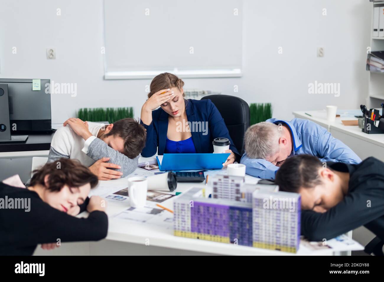 Gli uomini d'affari annoiati o stanchi dormono, riposandosi sul loro posto di lavoro durante la riunione, un concetto di uomini d'affari esausti annoiava, dormiva, stanchi. Foto Stock