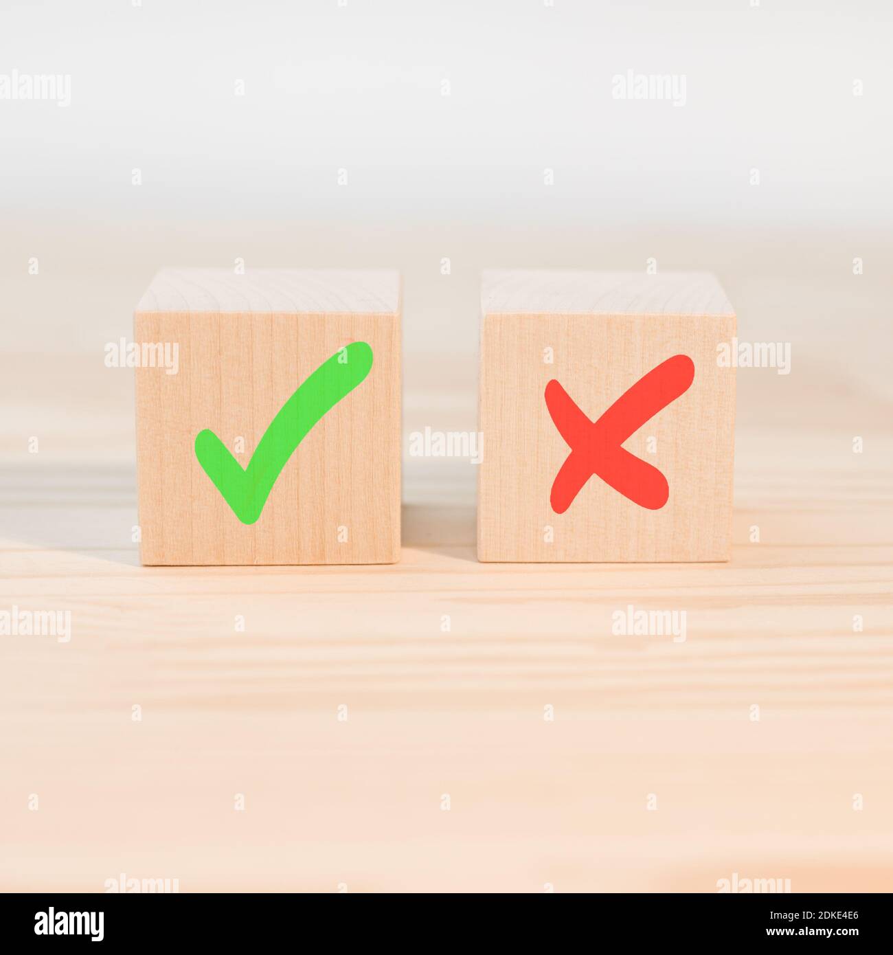 Concetto di decisione positiva o negativa o scelta di approvazione o rifiuto. Segno di spunta e segno di croce x su cubi di legno. Blocchi di legno con gre Foto Stock