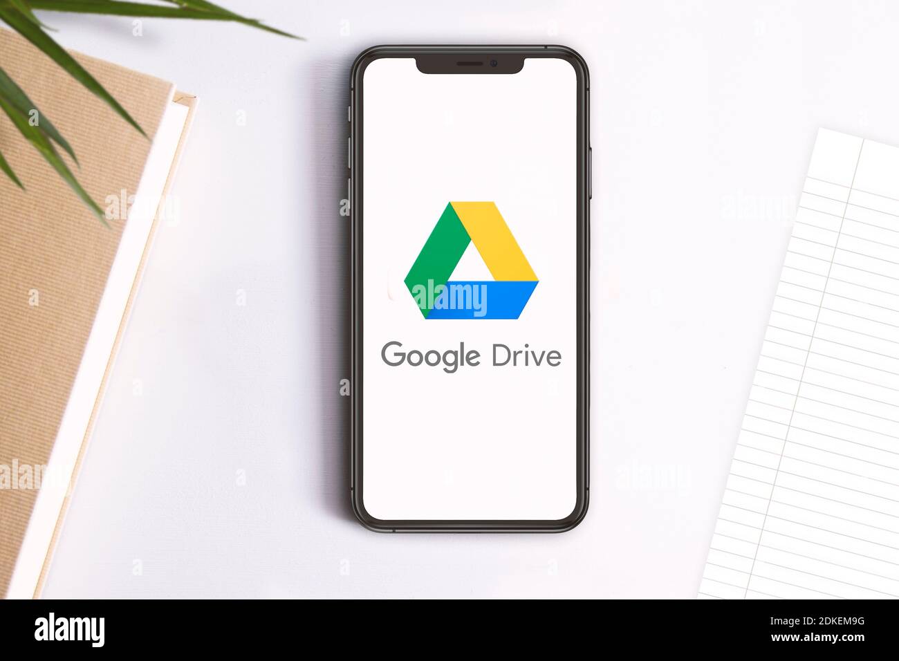 Smartphone con il logo dell'app Google Drive Service sullo schermo. Spazio di copia vuoto per il contenuto dell'editor. Foto Stock