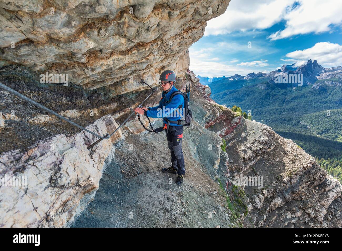 Giovane uomo di 22 anni lungo il percorso attrezzato Astaldi (caratteristico per le rocce colorate) ai piedi di Tofane, Cortina d'Ampezzo, Dolomiti, Belluno, Veneto, Italia Foto Stock