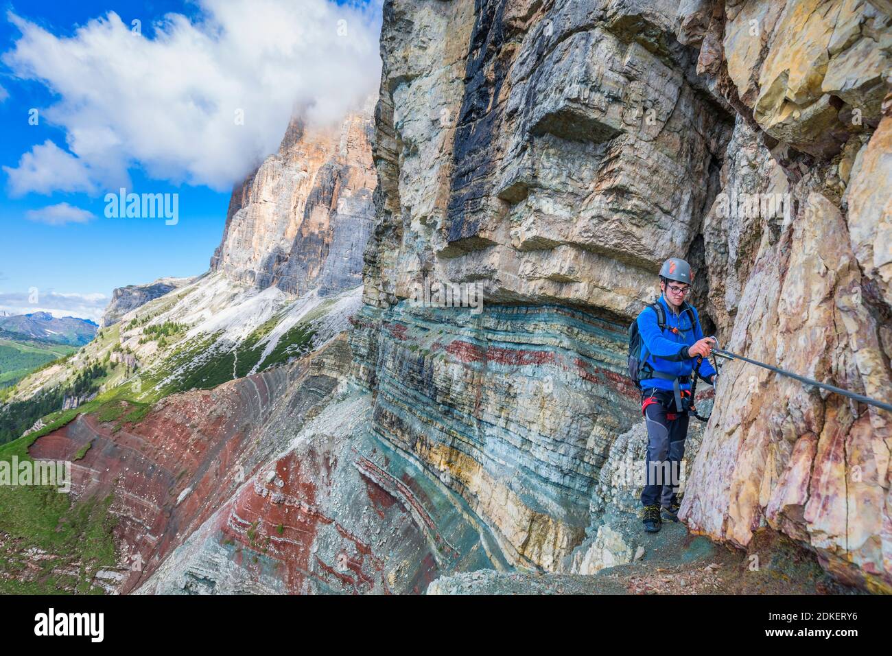 Giovane uomo di 22 anni lungo il percorso attrezzato Astaldi (caratteristico per le rocce colorate) ai piedi di Tofane, Cortina d'Ampezzo, Dolomiti, Belluno, Veneto, Italia Foto Stock