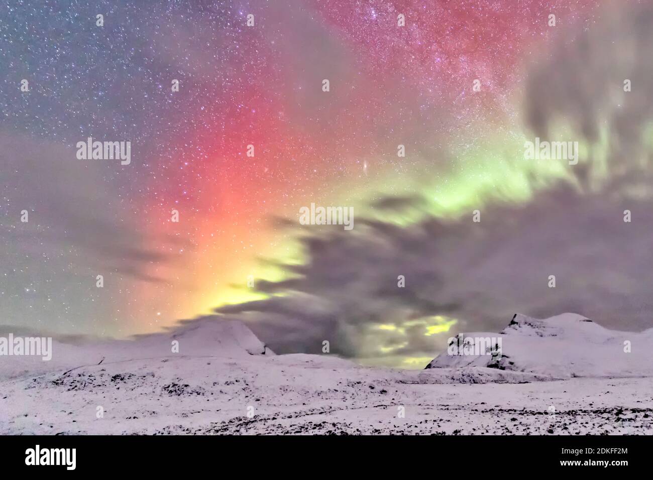 L'aurora boreale e le nuvole nel cielo stellato nelle alture innevate di Drumrunie, Scozia Foto Stock