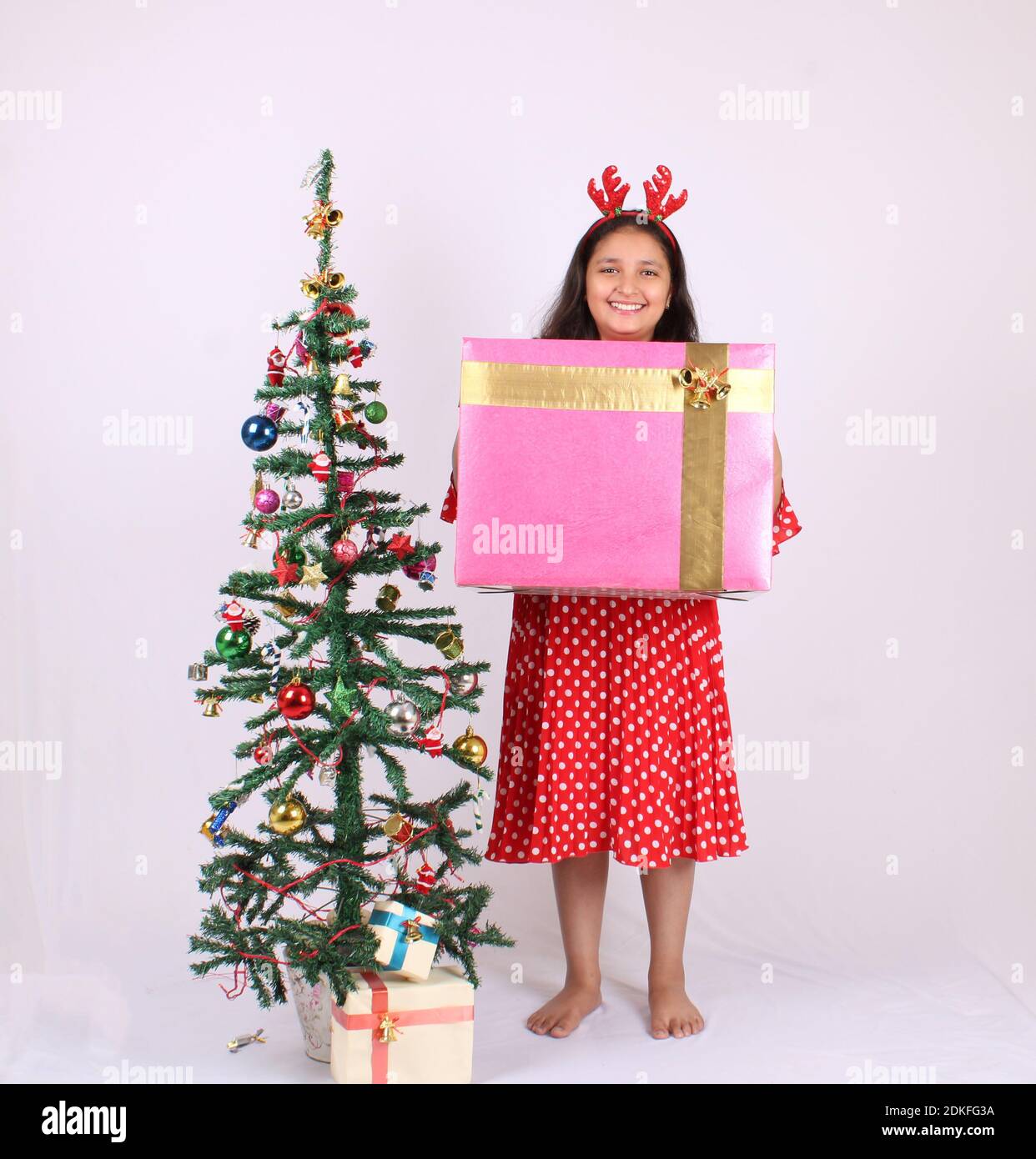 Carino piccola ragazza indiana che tiene regalo di Natale. Foto Stock