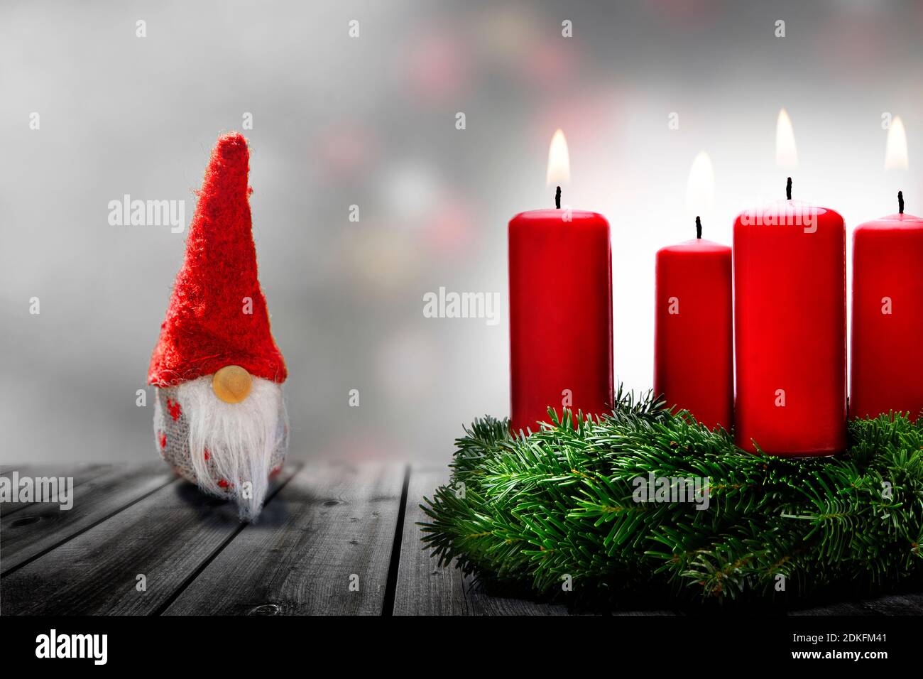 Babbo Natale nella neve, corona dell'avvento con 4 candele brucianti Foto Stock
