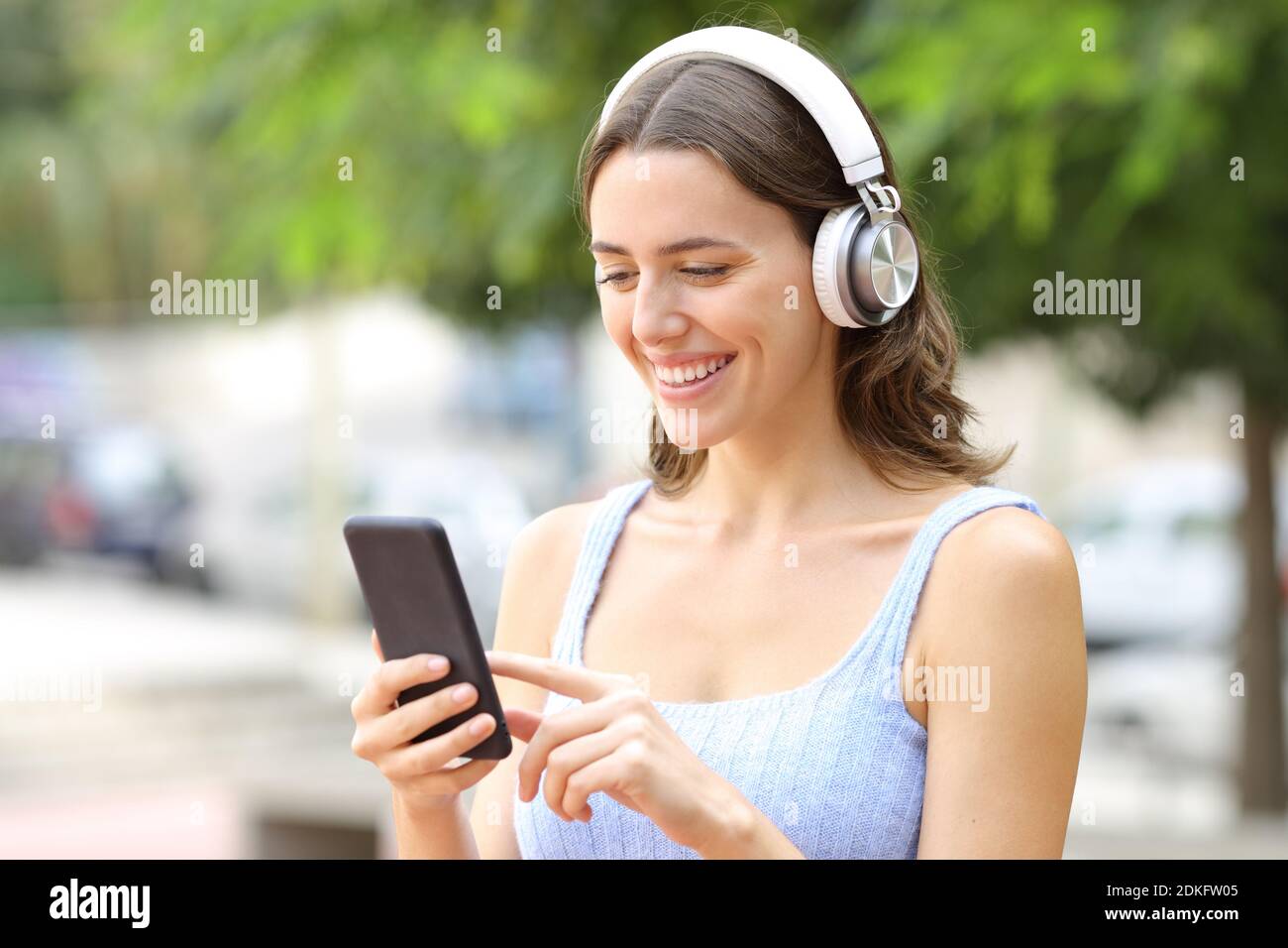 Buon teen ad ascoltare musica con smartphone e wireless cuffie Foto Stock