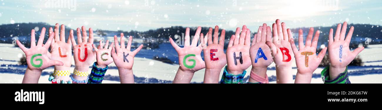 Bambini mani costruire parola Glueck Gehabt significa Lucky, Snowy Inverno sfondo Foto Stock