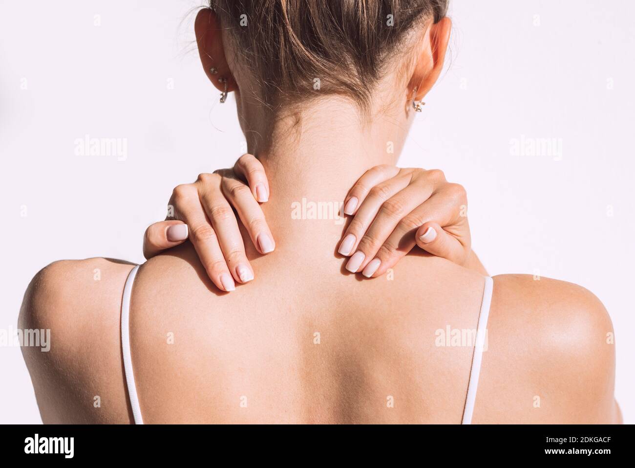 Donna dalla schiena con dolore al collo o alle spalle. Lesione o spasmo muscolare. Foto Stock