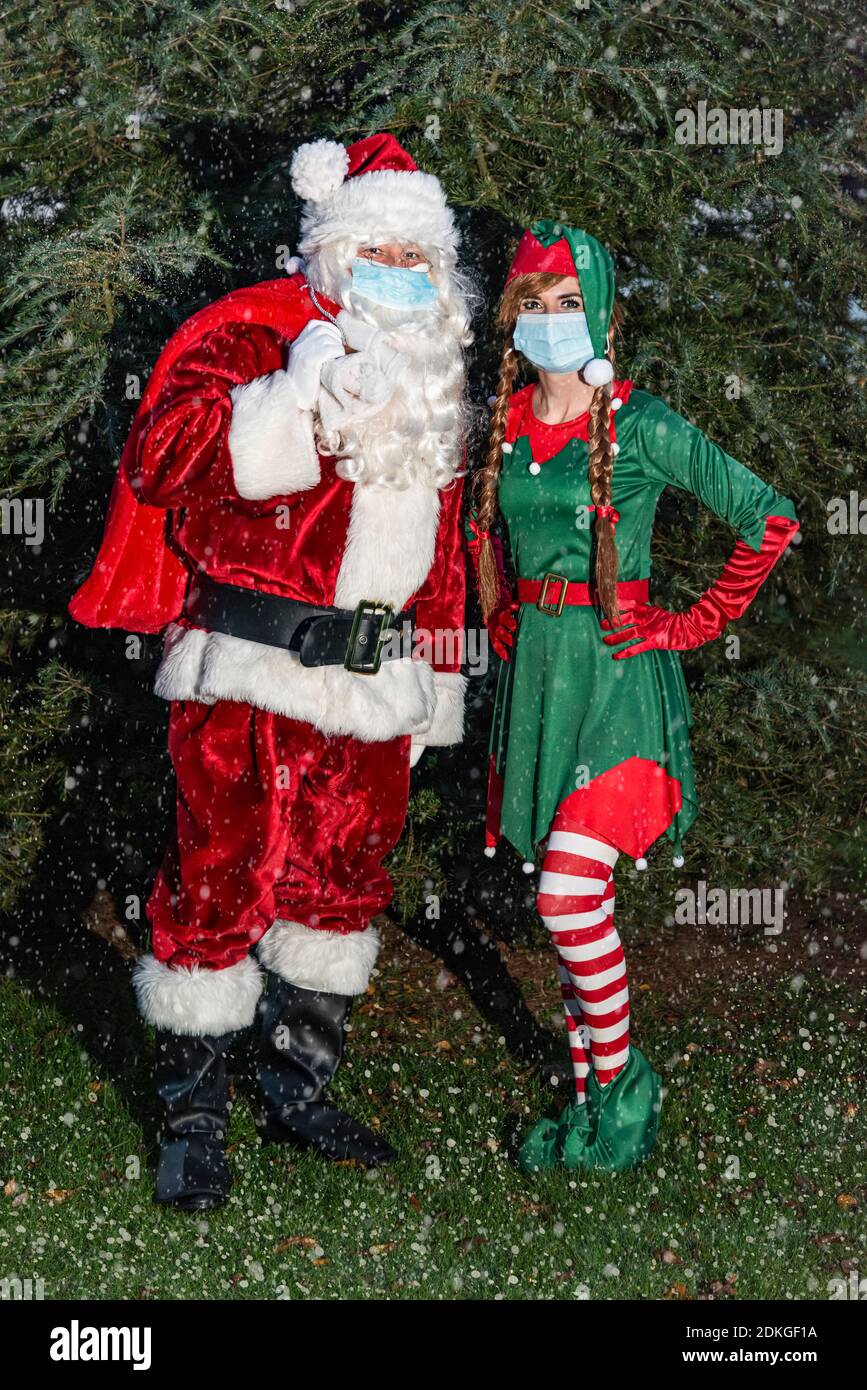 Regno Unito, Quorn - Novembre 2020: Santa e un Elf indossano in maschere di faccia mentre vanno i nostri regali di consegna come la neve comincia a cadere Foto Stock