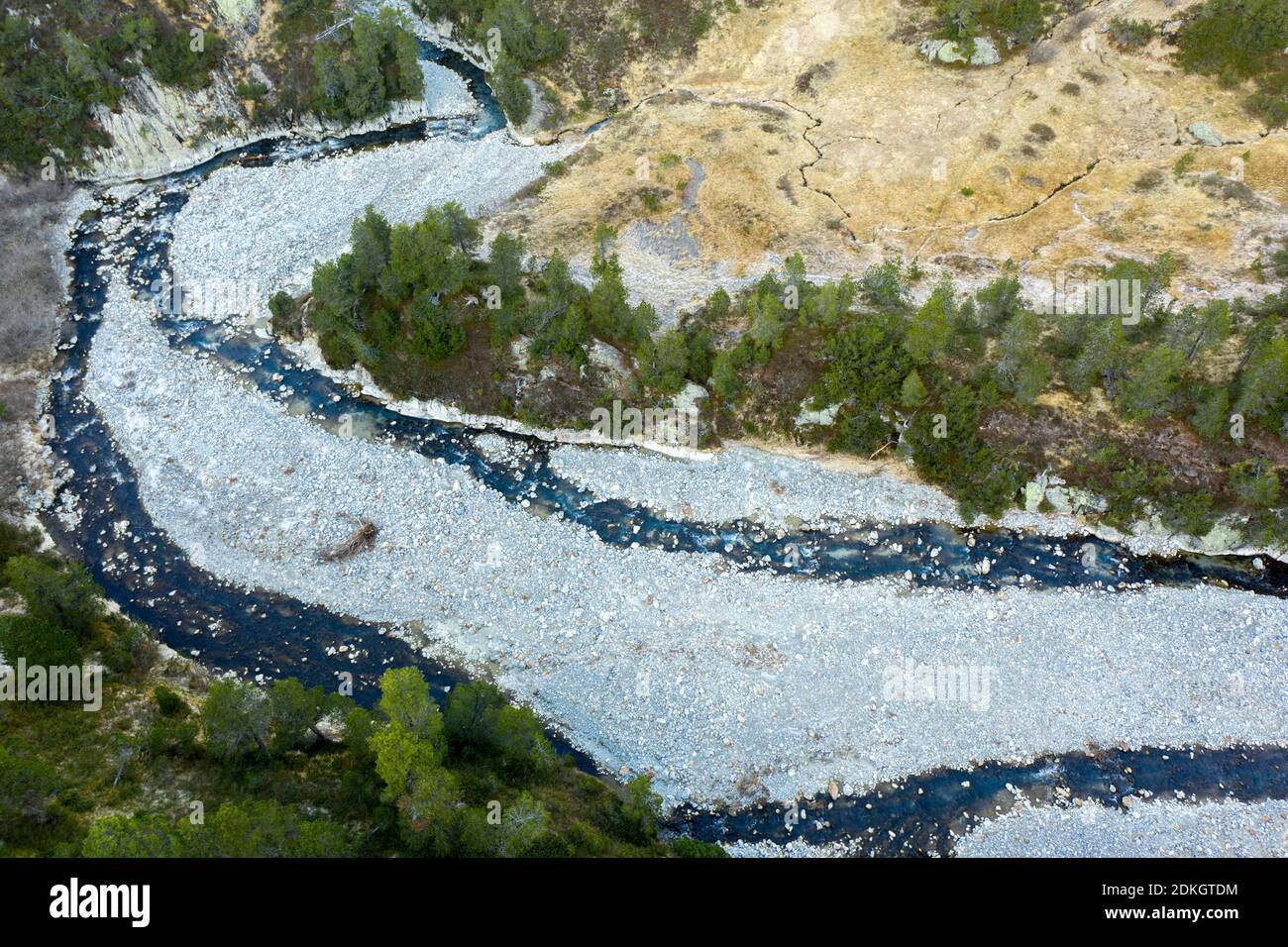 Scatti aerei di ruscello di montagna alla linea dell'albero dentro le alte montagne Foto Stock