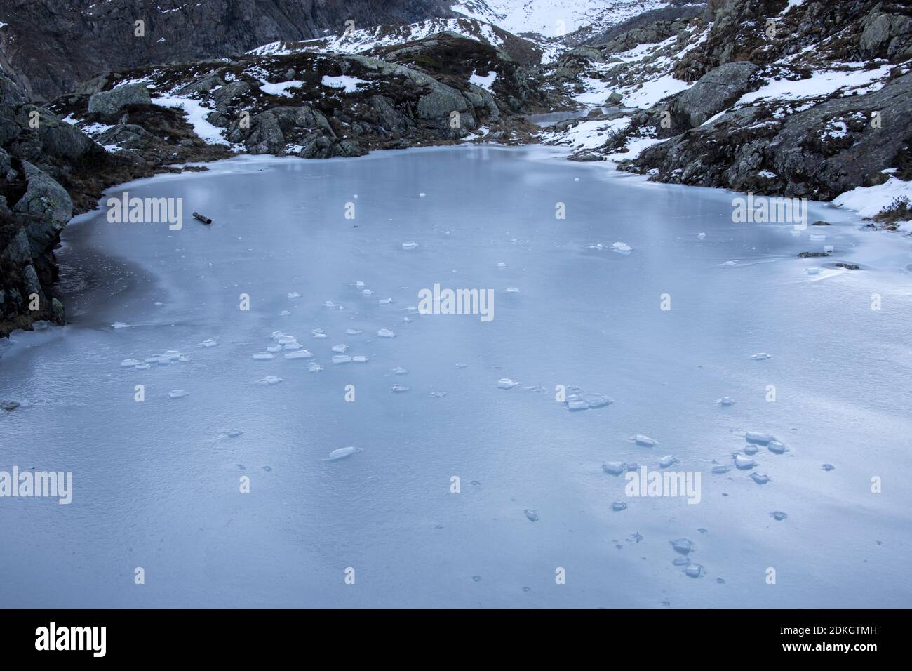 lago di montagna ghiacciato dopo una notte fredda Foto Stock