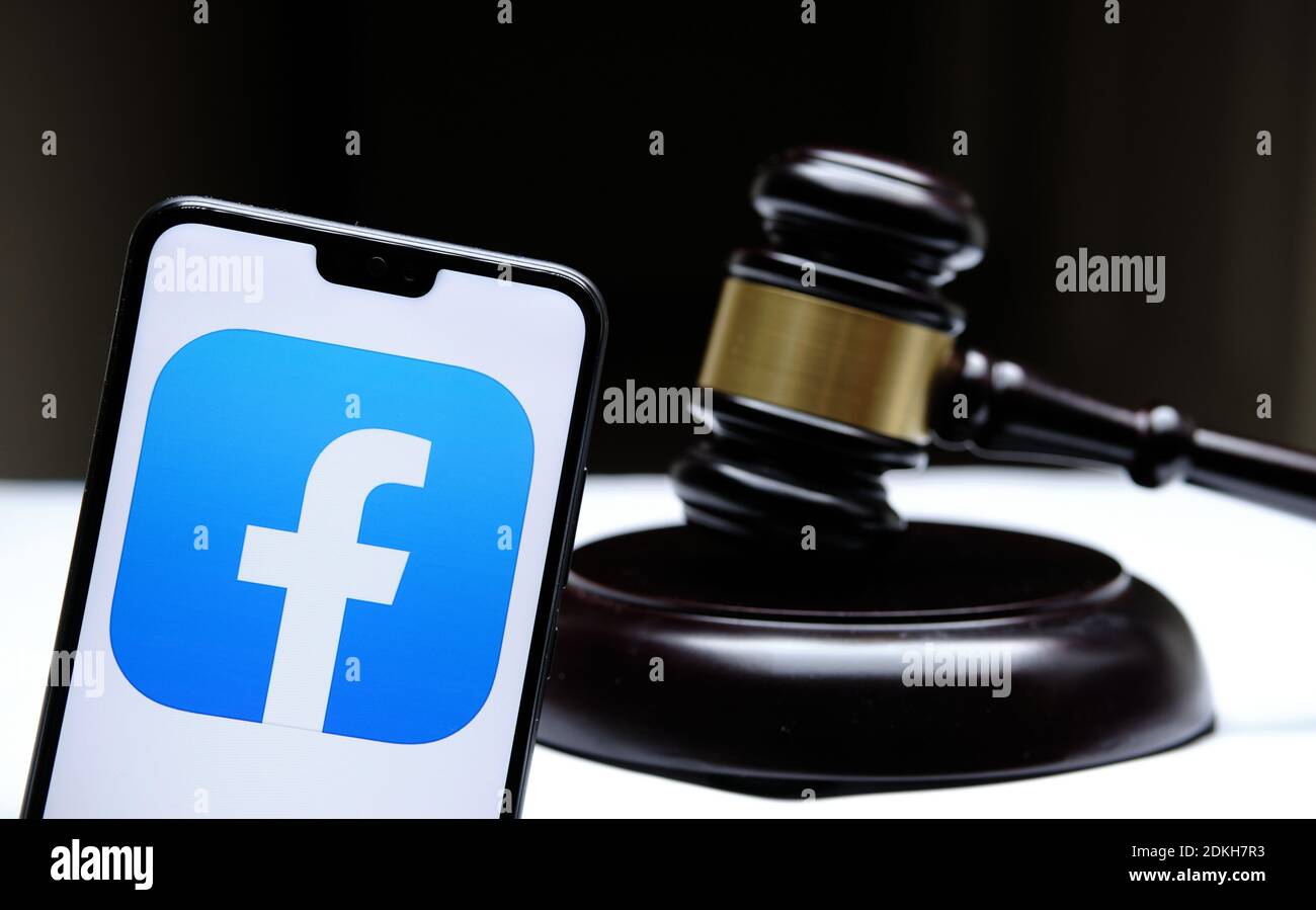 Stafford, Regno Unito - Dicembre 15 2020: Il logo di Facebook visto sullo smartphone posto accanto al gavel dei giudici. Concetto di causa legale, Foto Stock