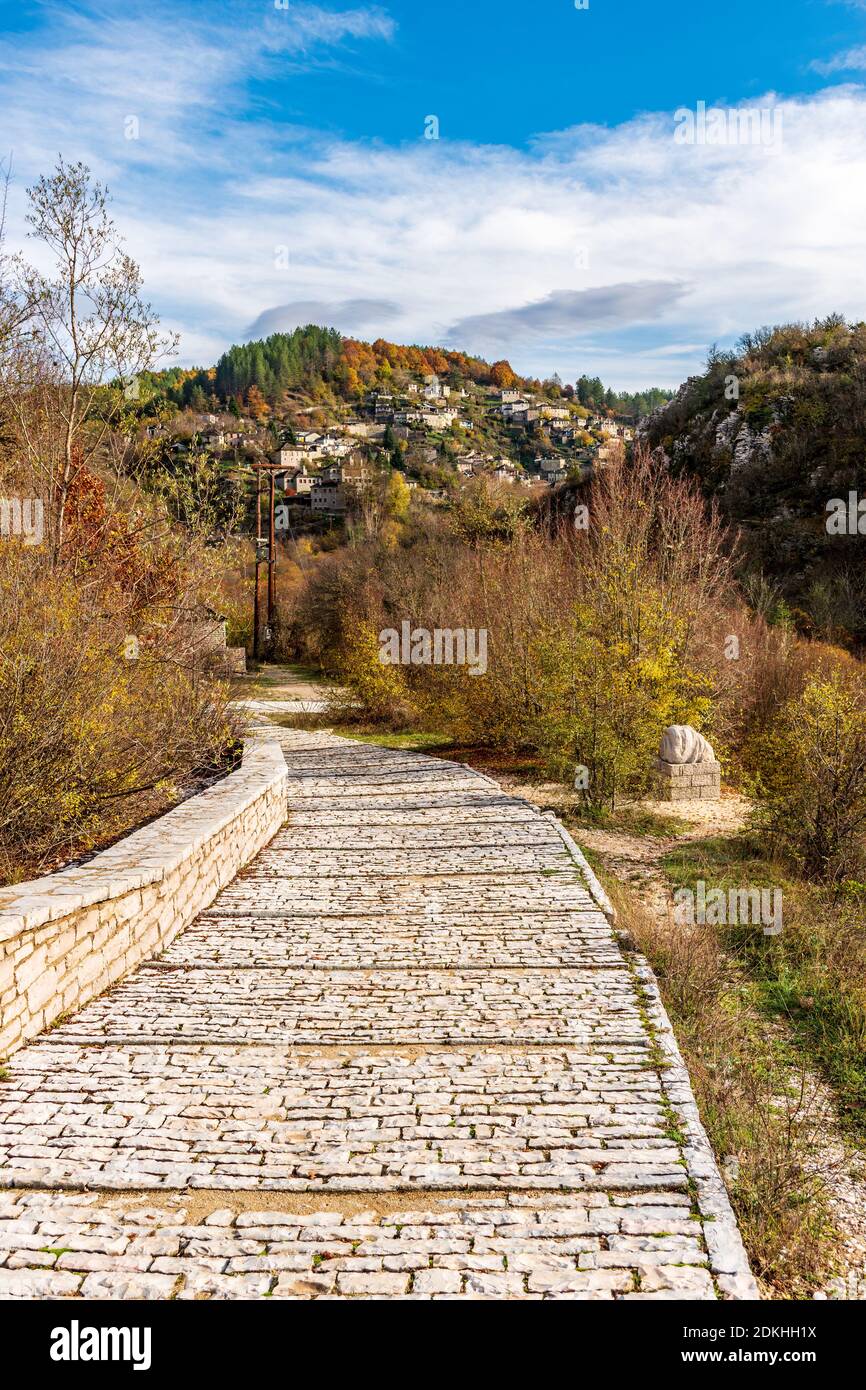 Strada in pietra che conduce al vecchio ponte di Kalogeriko (Plakida) durante la caduta Stagione situata sul fiume di Voidomatis e kipoi vilage Come sfondo a Zago Foto Stock