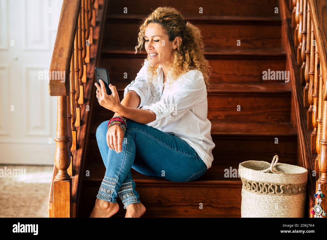 Bella donna adulta a casa nell'attività di videochiamata in conferenza - tecnologia e connessione internet per chiamare amici o genitori - persone e nuove strutture di stile di vita moderno - giovani graziosi femmina e cellulare Foto Stock