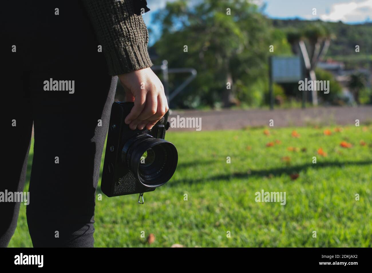 Bambina che tiene una telecamera analogica nel parco all'aperto Foto Stock