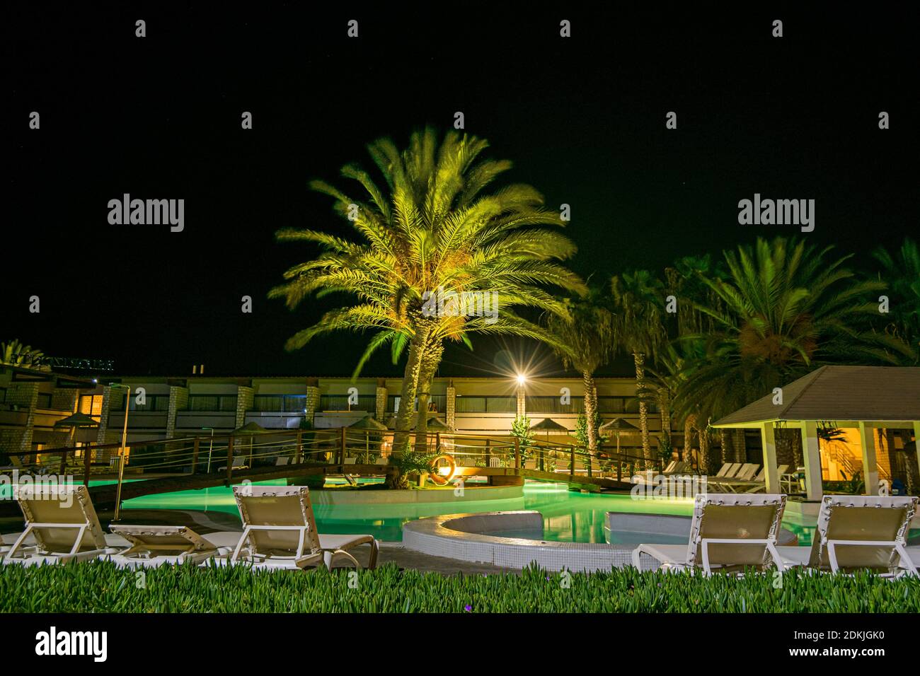 Vista sulla piscina dell'hotel con palme e bar della piscina di notte in estate. Hotel Belorizonte a Cabo Verde Santa Maria Salt Island Foto Stock