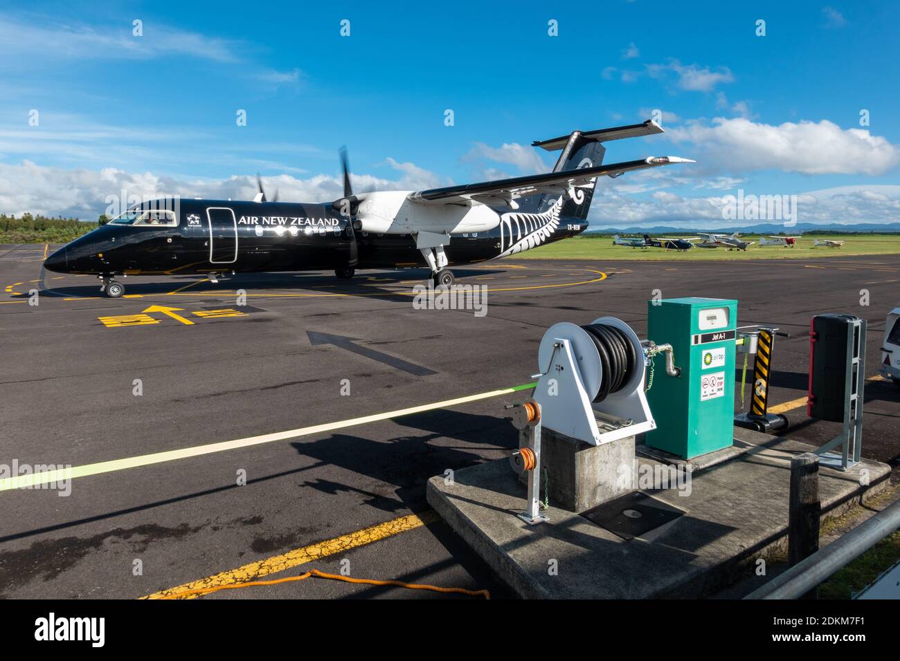 Una serie Bombardier Dash 8 Q300 dipinta in tutti i colori neri si avvia accanto a una pompa di alimentazione Jet A1 all'aeroporto di Taupo, Nuova Zelanda Foto Stock