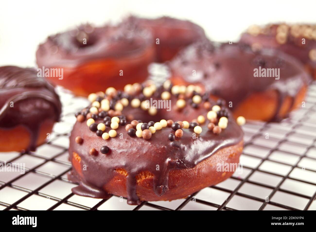 Ciambella sulla griglia da forno smaltata con crema al cioccolato o glassa. Concetto di colazione Foto Stock