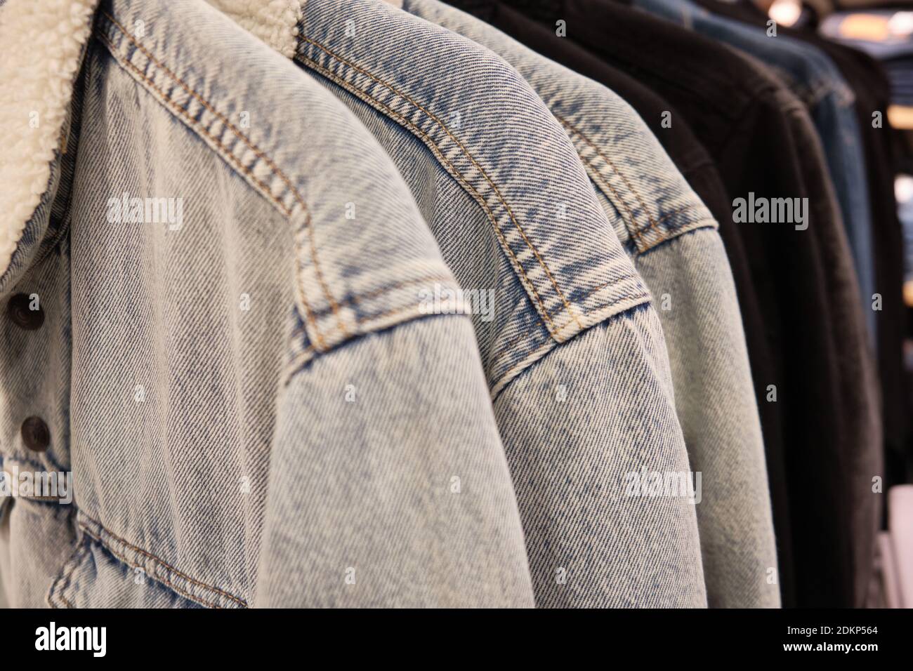 Giacche Sherpa su appendiabiti. Giacche in denim caldi casual presso il negozio al dettaglio Foto Stock