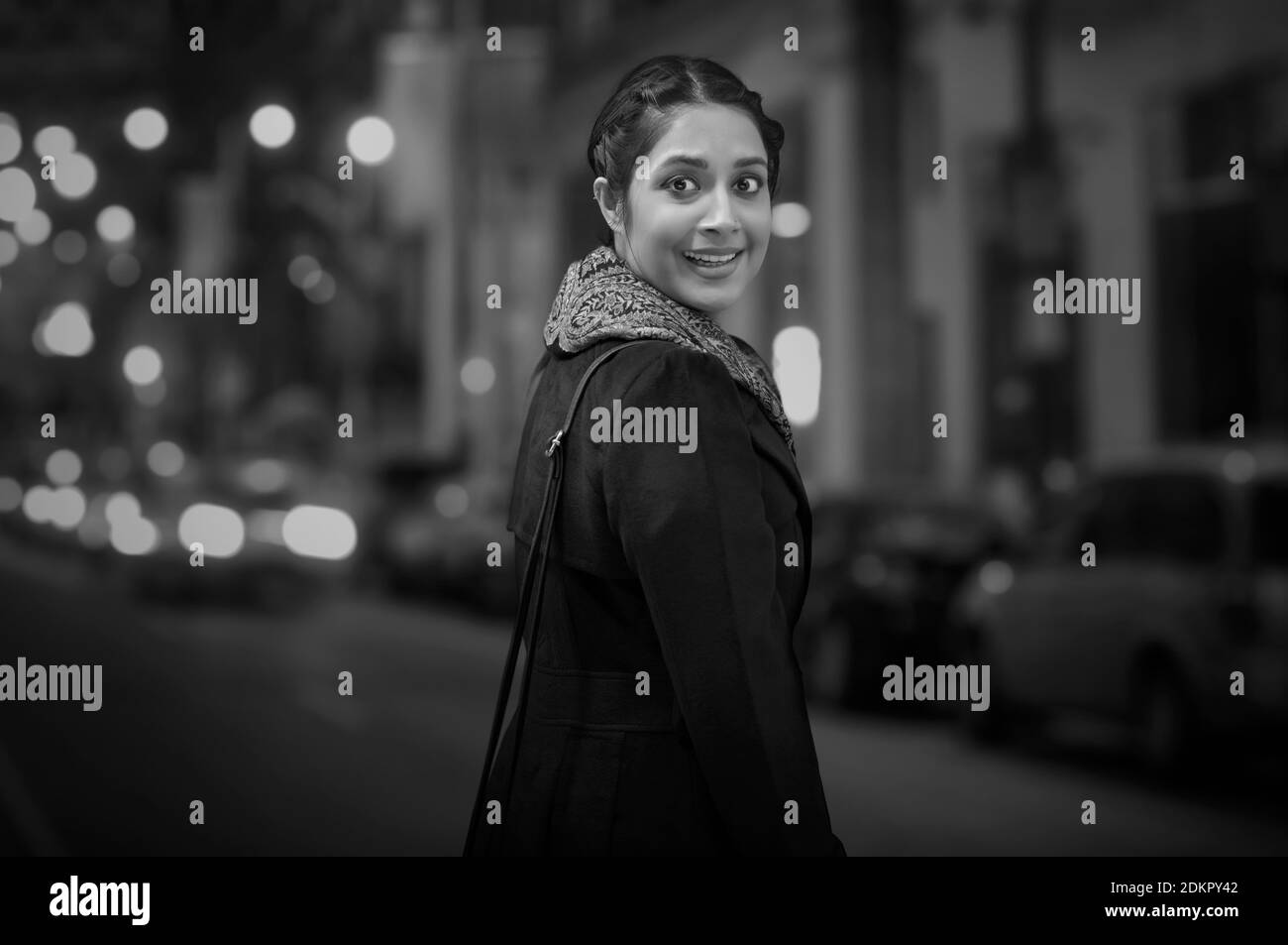 UNA GIOVANE DONNA CHE SI GIRA INTORNO E GUARDA CON STUPORE Foto Stock