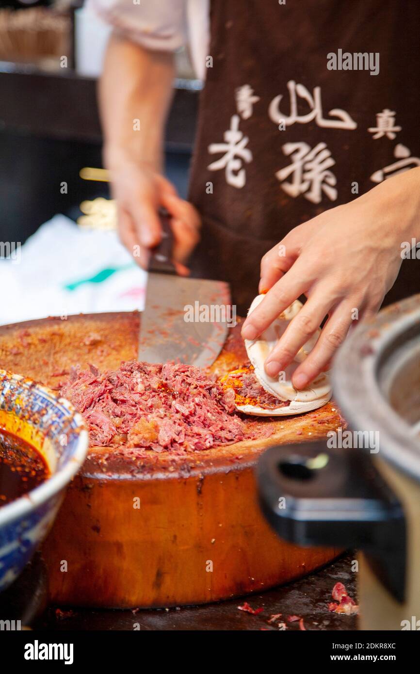 Preparazione di hamburger di mutton con panino pita al cibo di strada Fornitore nel quartiere musulmano Xian Xi'an Cina Foto Stock