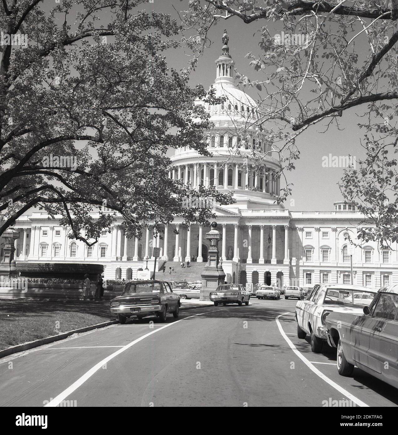 Anni '1960, auto storiche di quest'epoca parcheggiate in una strada su Capitol Hill fuori dal Campidoglio degli Stati Uniti, Washington DC, USA. Costruito in stile neoclassico, con una cupola e grandi colonne, è la sede del Congresso degli Stati Uniti, il ramo legislativo del governo federale e ospita le camere del corpo superiore, il Senato e il corpo inferiore, la camera dei rappresentanti, i due organi che compongono il ramo legislativo del governo americano. Foto Stock