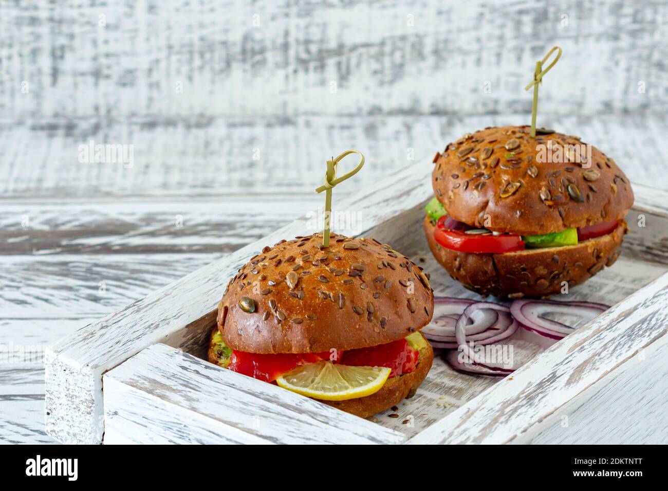 panino intero farcito con insalata, salmone, avocado e pomodori. Concetto di cibo sano. Foto Stock