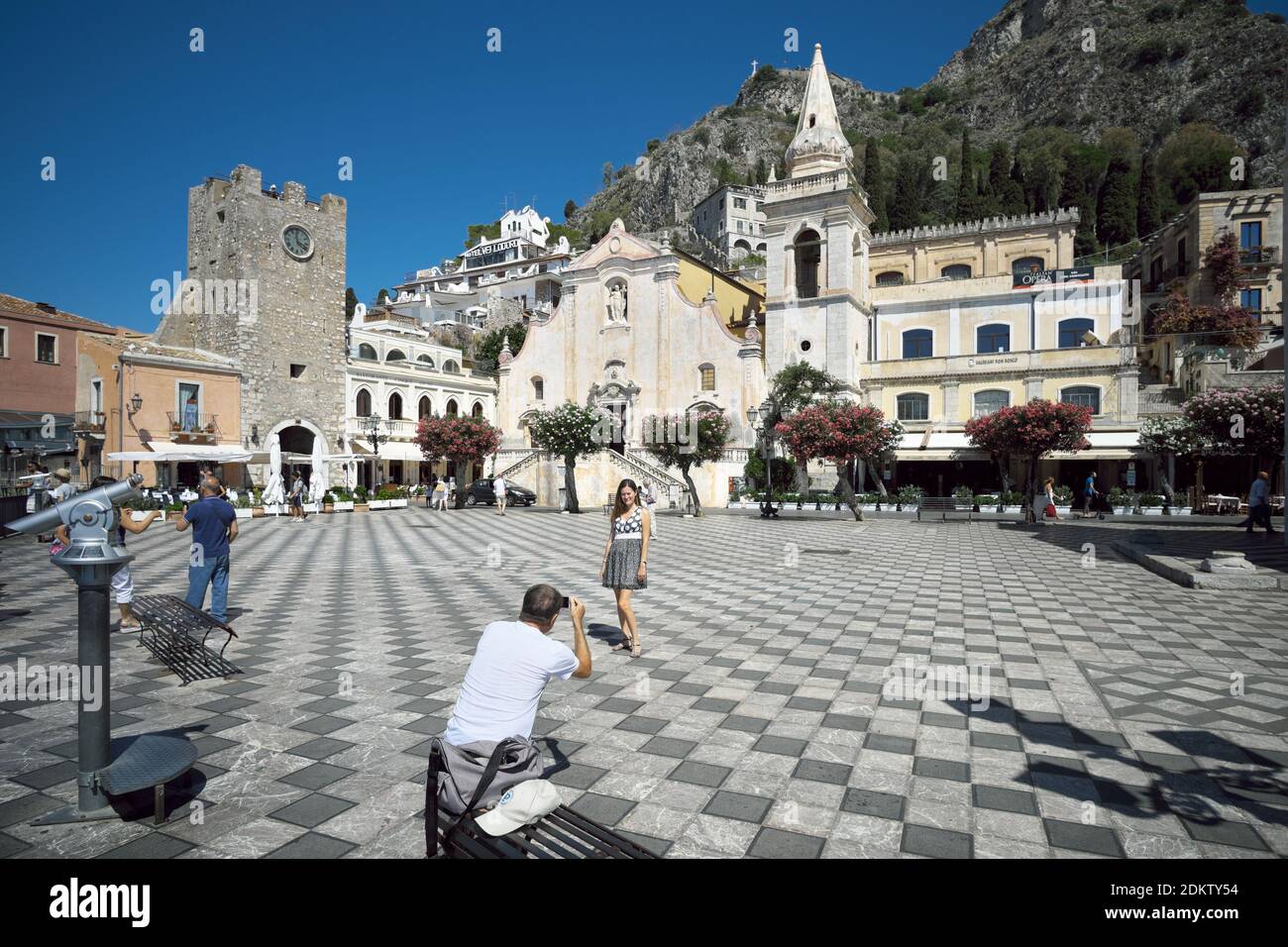 La piazza principale del centro storico di Taormina, punto di riferimento del turismo, una donna che posa per un souvenir fotografico Foto Stock