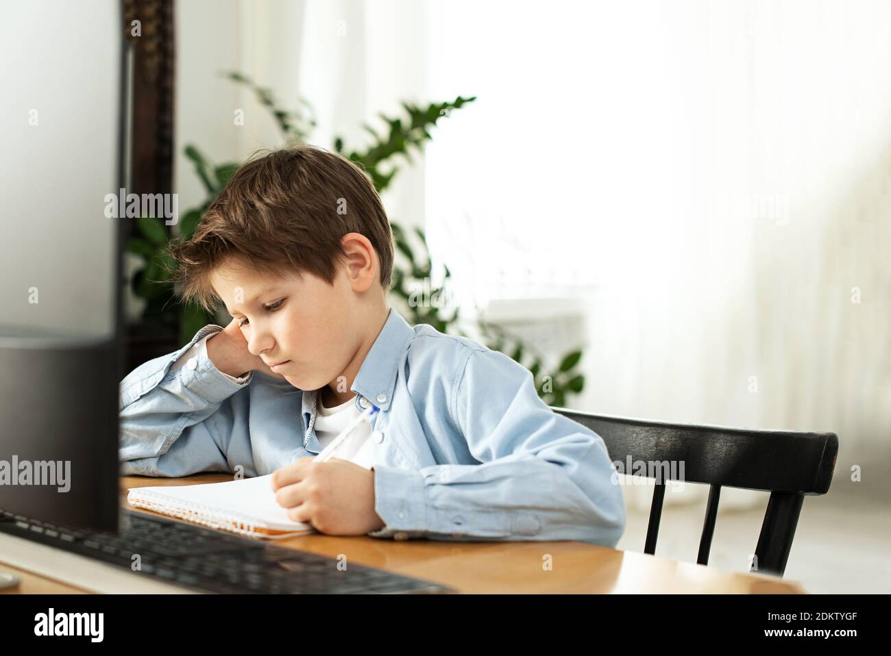 Apprendimento a distanza durante l'isolamento durante la quarantena nel coronovirus. Ragazzo e laptop a casa. Stile di vita. Foto Stock