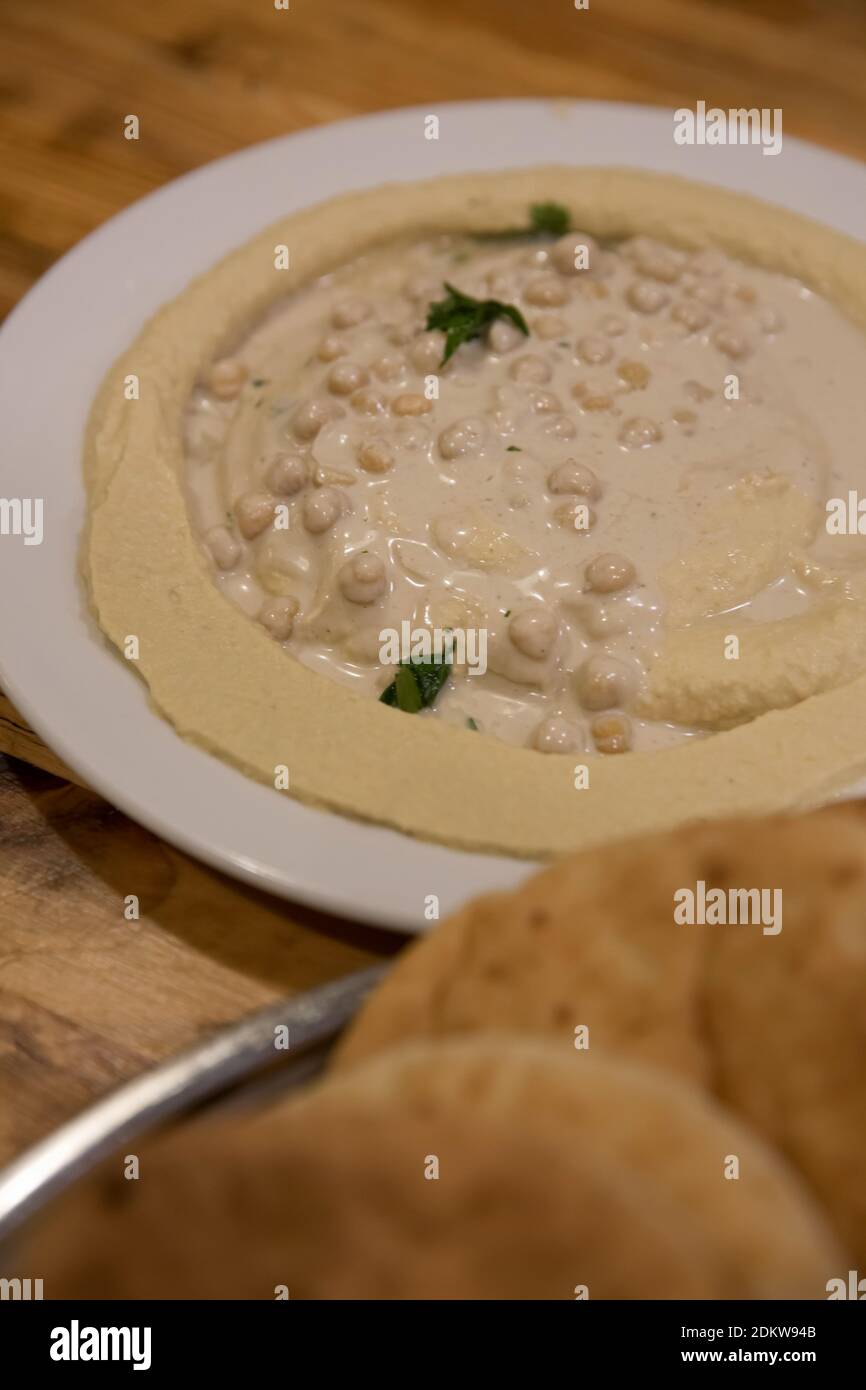 Una porzione di humus, tahini, olio d'oliva e prezzemolo una pasta mediorientale a base di ceci Foto Stock