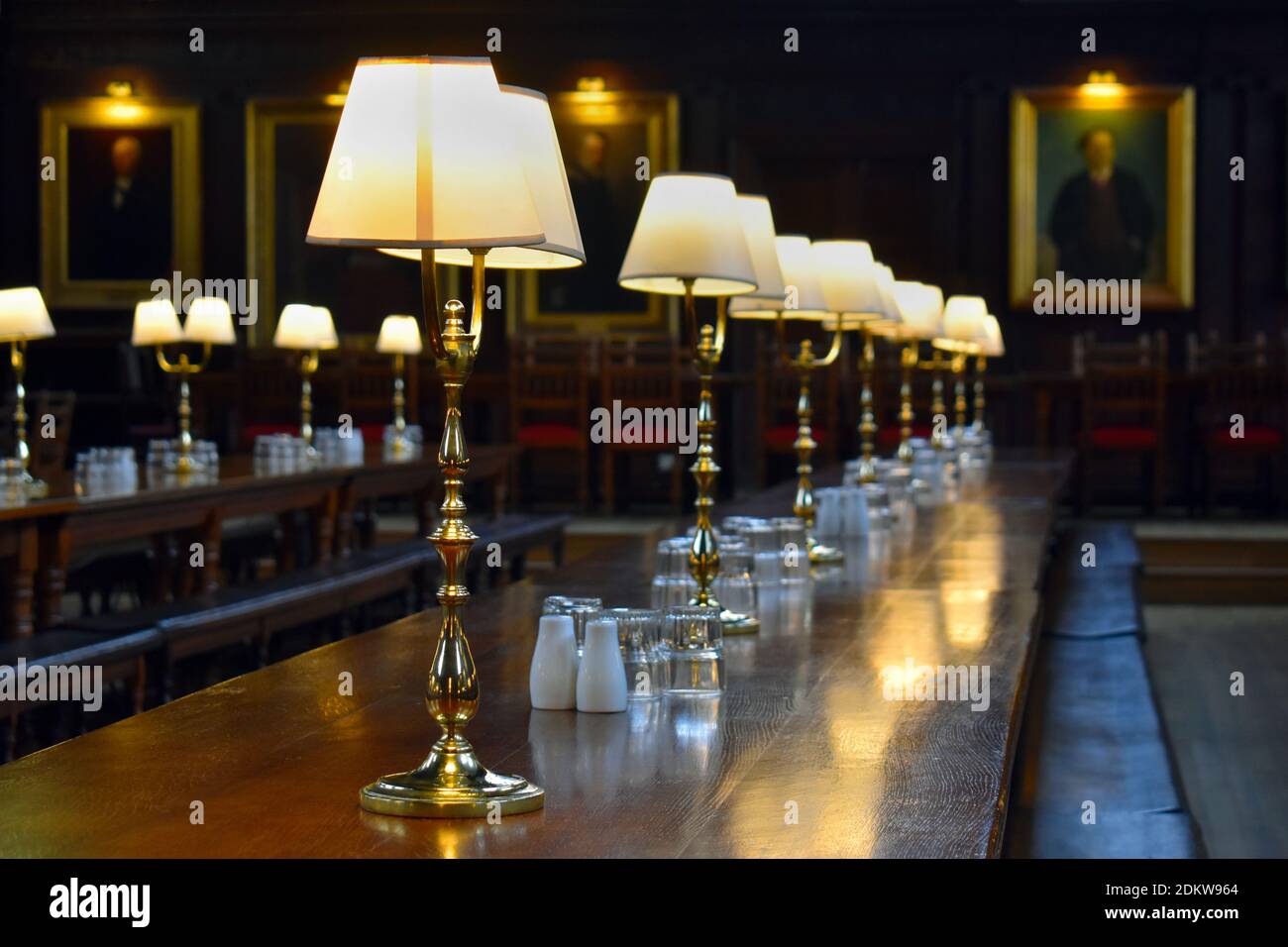 Lampade su tavolo di legno in vecchio refettorio Foto Stock