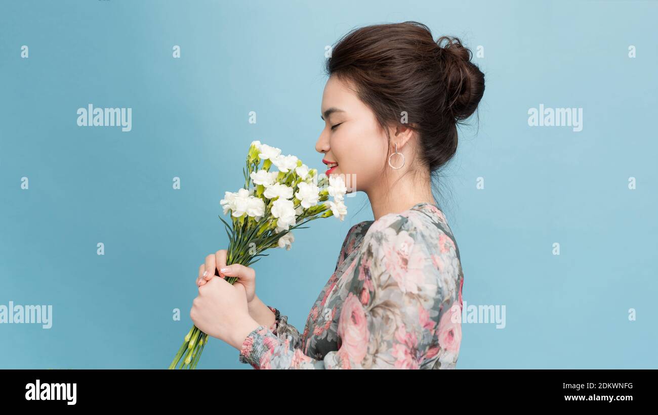 San Valentino - Dreaming Voluptuous giovane donna con bouquet di Fiori in piedi su sfondo blu Foto Stock