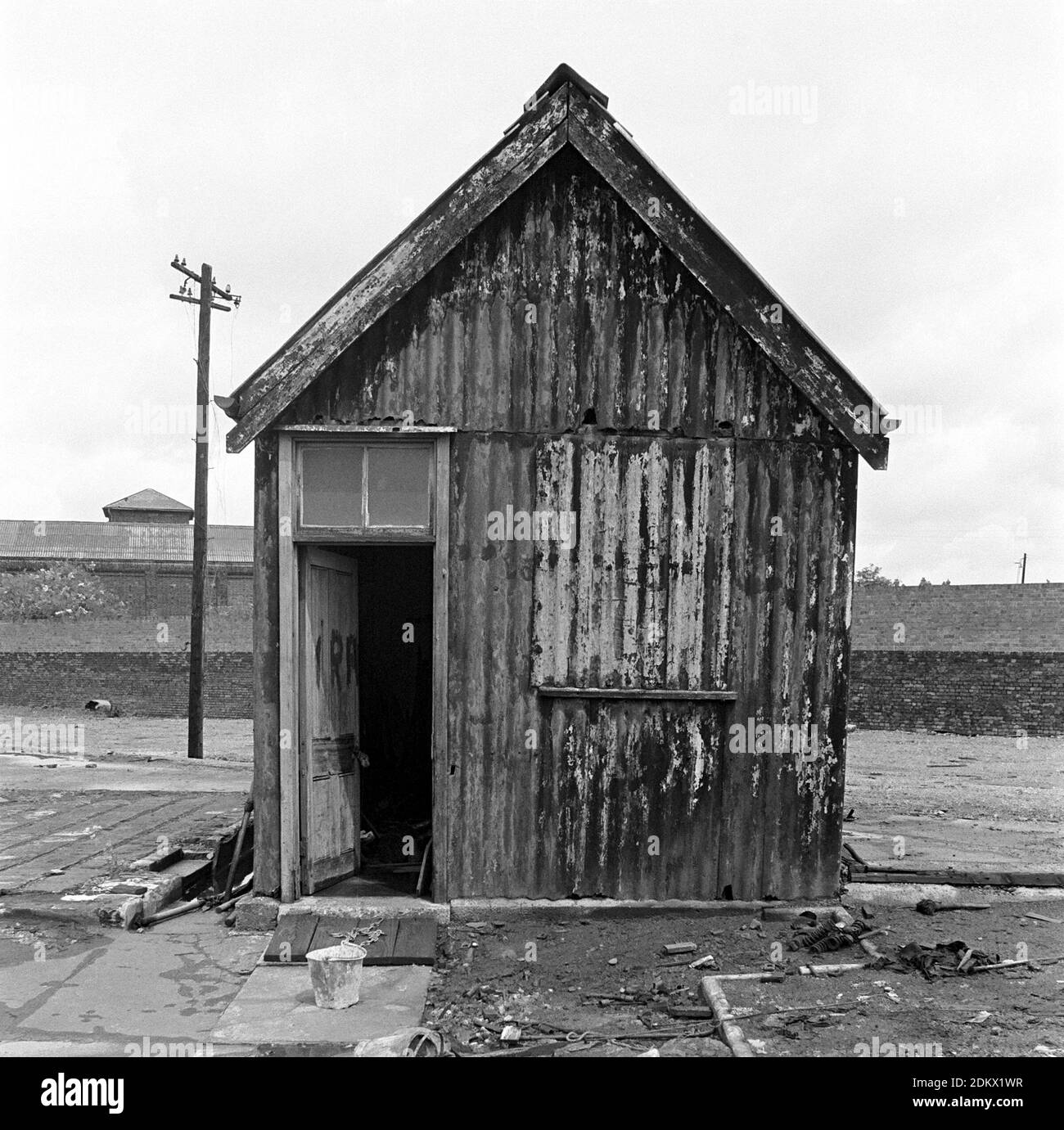 Regno Unito, Londra, Docklands, Isola dei cani, banchine di spedizione, inizio 1974. Una capanna dilapidata con graffiti IRA sulla porta. West India Docks. Foto Stock