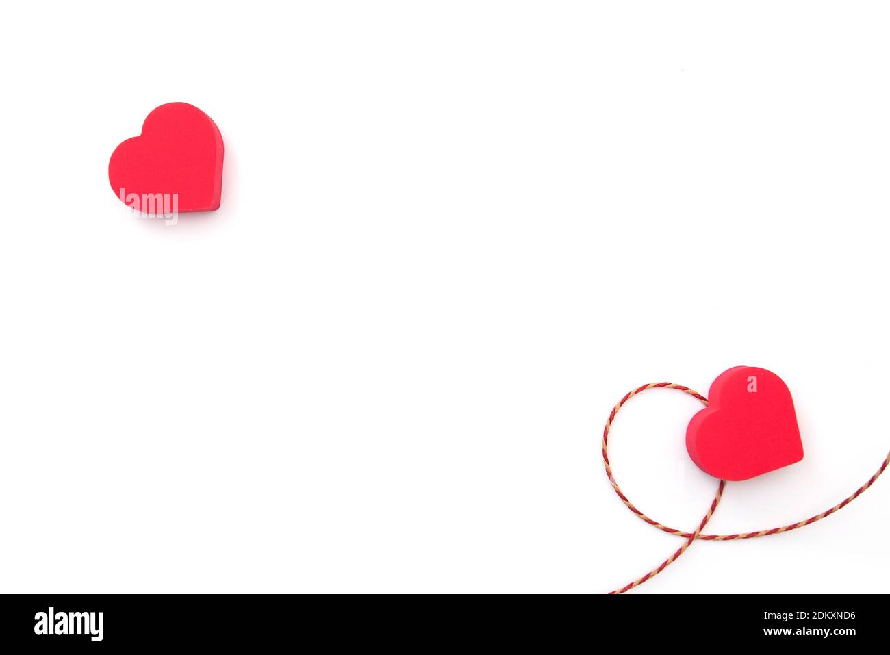 Due cuori rossi sulla superficie bianca, layout, spazio per il testo. Cartolina per il giorno di San Valentino o la celebrazione del matrimonio Foto Stock