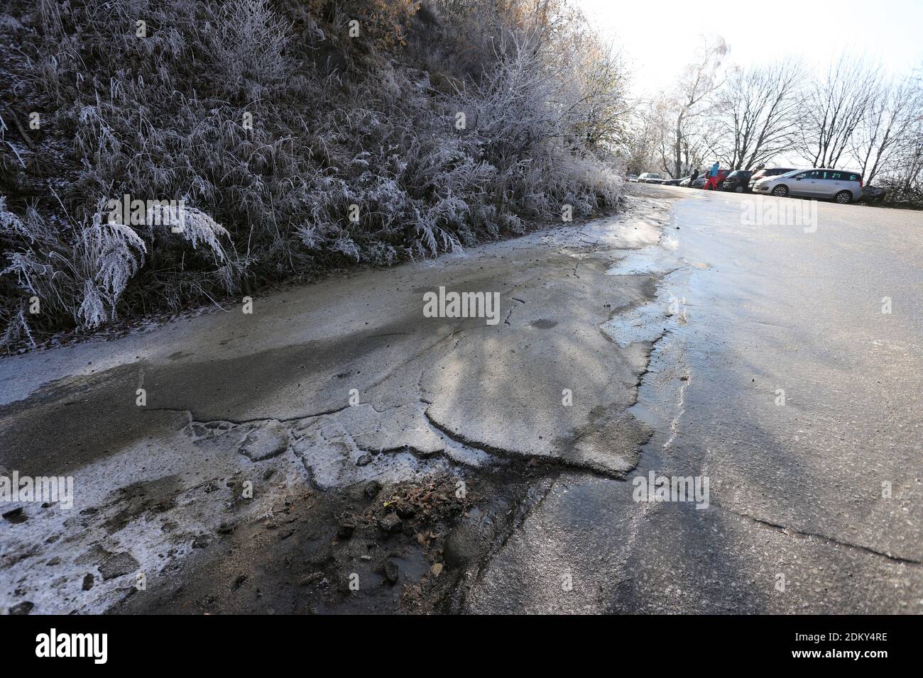 Curva ghiacciata su una strada in rovina in inverno. Foto Stock