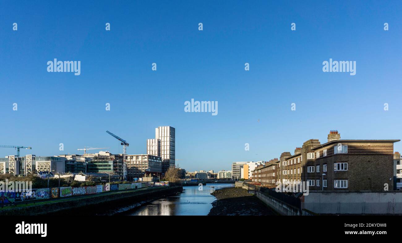 Il fiume Dodder a Dublino, Irlanda, che scorre attraverso il villaggio di Ringsend sulla destra con i moderni edifici del Grand Canal Docks in avanti Foto Stock