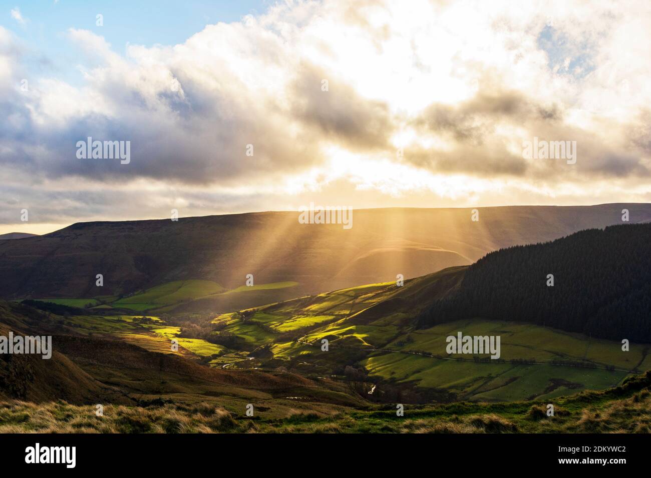 Raggi di sole che si infrangono attraverso le nuvole sulla valle di Alport Foto Stock