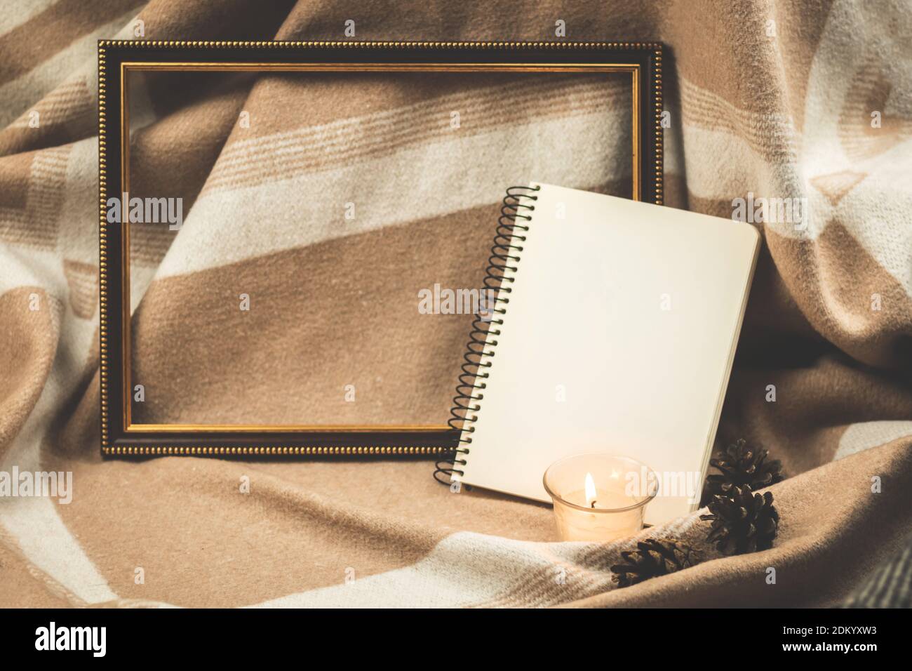 Composizione accogliente, sfondo con cornice in legno, blocco note e candela, copia spazio foto Foto Stock