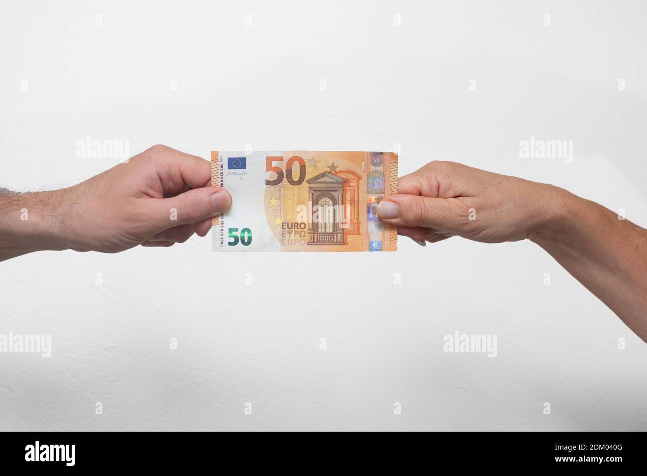 Mani umane che tirano una banconota da 50 Euro Foto Stock