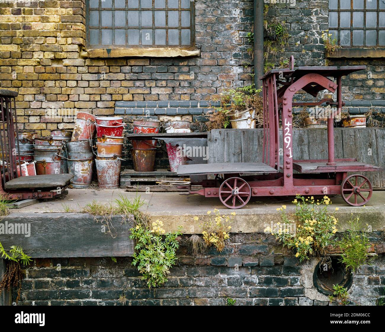 Regno Unito, Londra, Docklands, Isola dei cani, banchine di spedizione, inizio 1974. Magazzino disutilizzato accanto alla ferrovia. Una piattaforma di pesatura su ruote e benne antincendio. Foto Stock