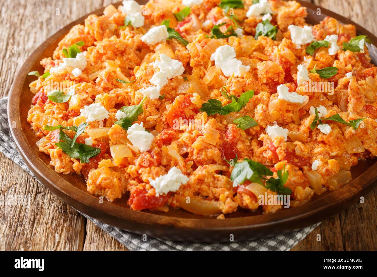 Deliziose uova strapazzate con pomodori e formaggio feta primo piano in un piatto sul tavolo. Orizzontale Foto Stock
