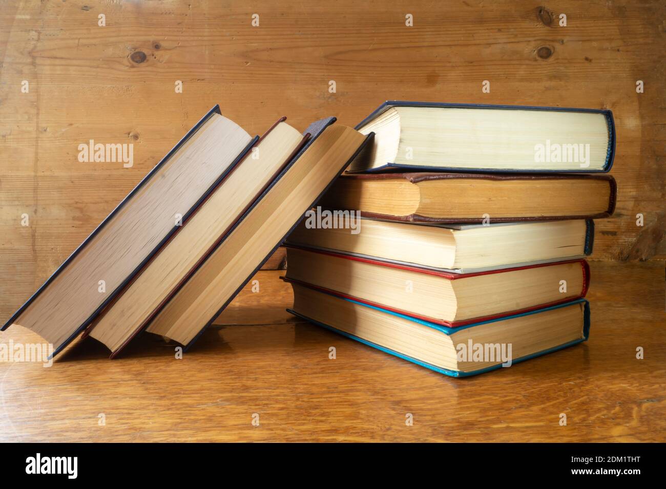 La pila dei libri poggia su reggimento di legno. Soggetti in primo piano armadio Foto Stock