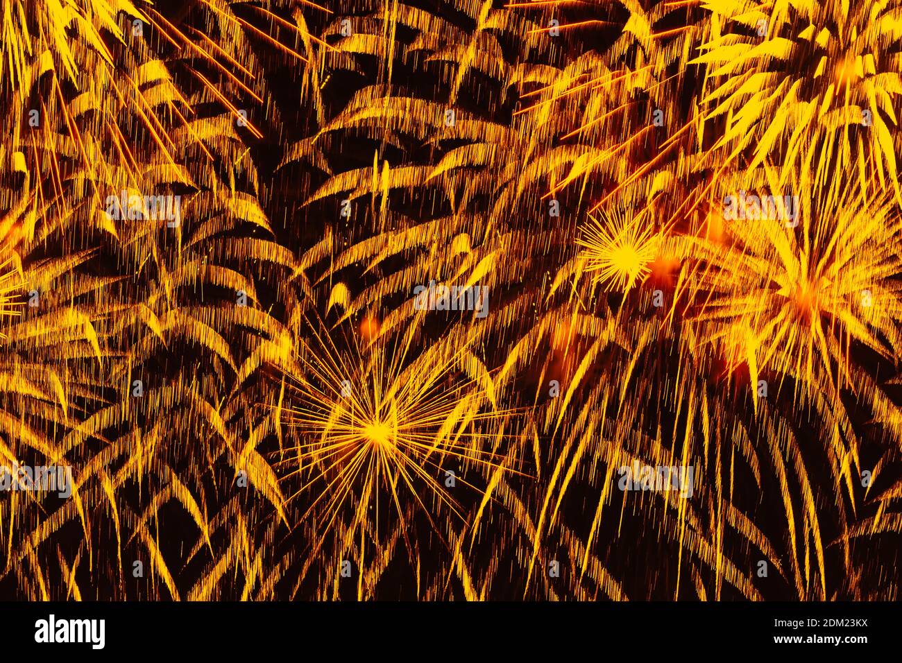 Fuochi d'artificio di festa. Scintille dorate colorate, pioggia di comete incandescenti e stelle scintillanti su cielo nero. Sfondo festivo astratto Foto Stock