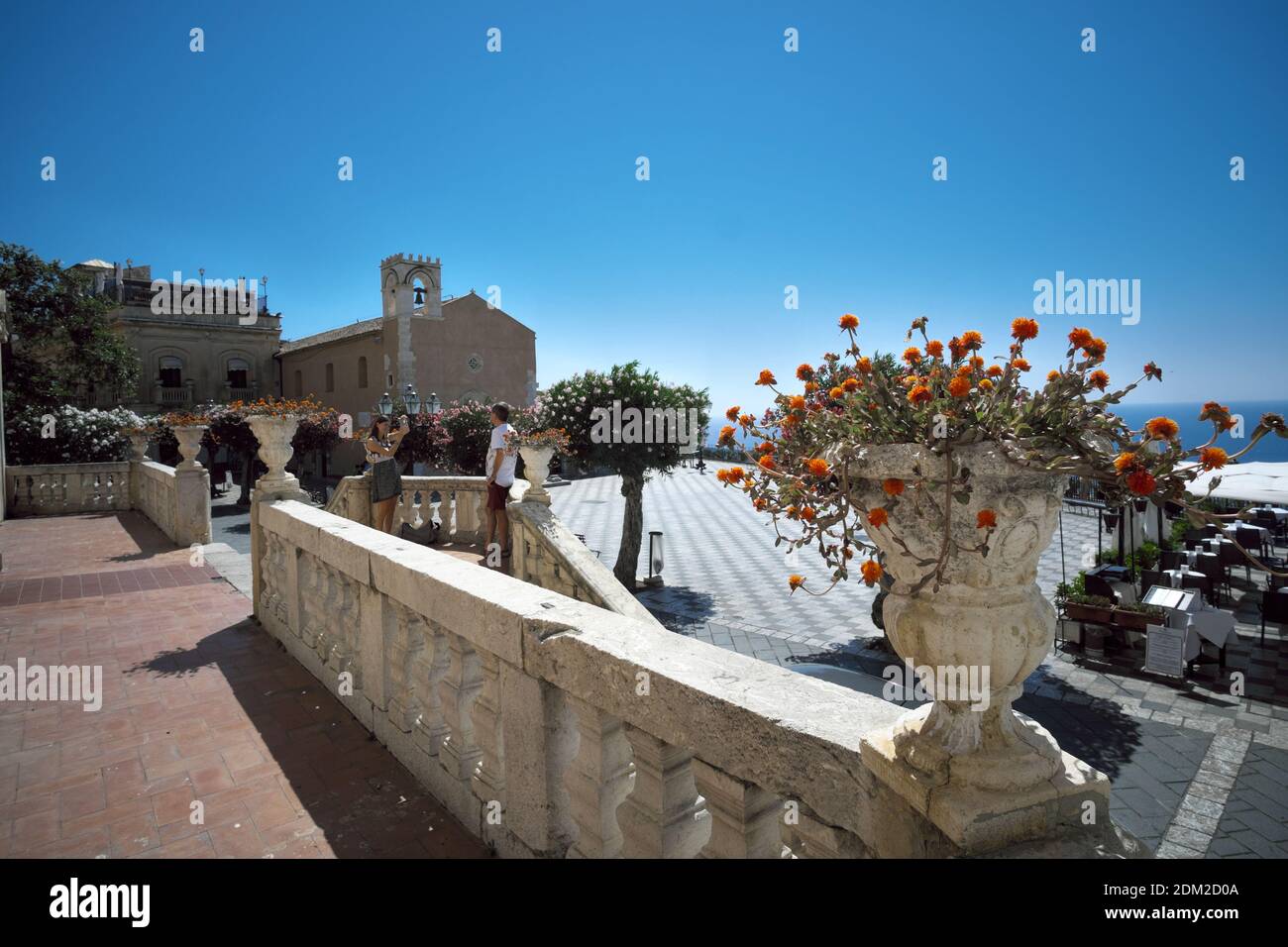 Taormina Centro storico di Sicilia punto di riferimento del turismo, una coppia scattando foto, l'uomo che posa per un ricordo fotografico Foto Stock