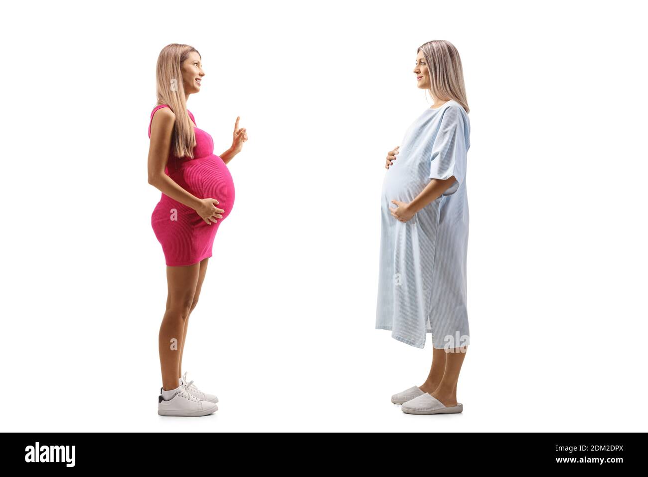 Foto di profilo di lunghezza completa di una donna incinta in un abito da paziente e una donna incinta in un abito rosa parlare isolato su sfondo bianco Foto Stock