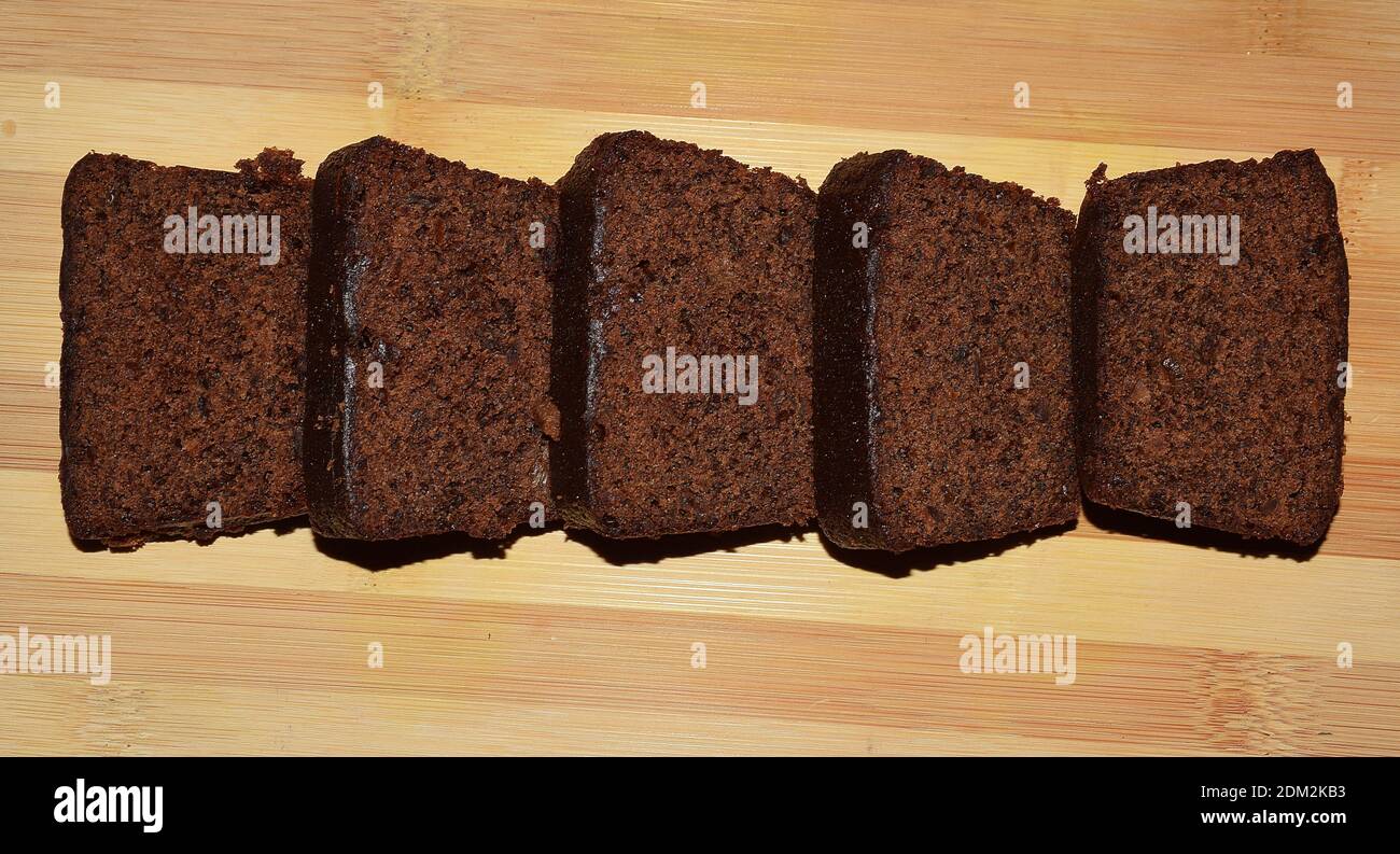 Pezzi di torta di prugna scura fatti in casa fatti durante natale il uno sfondo di legno Foto Stock